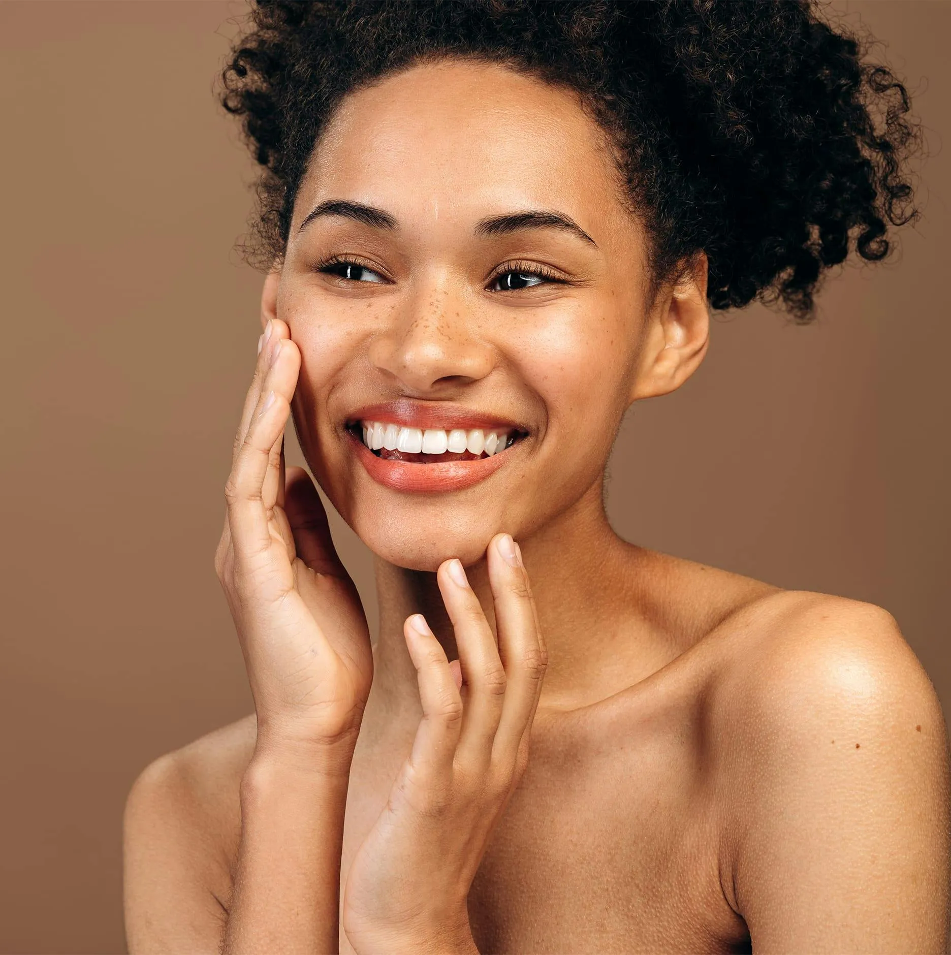 Woman with curly hair smiling after temporalis myoplasty